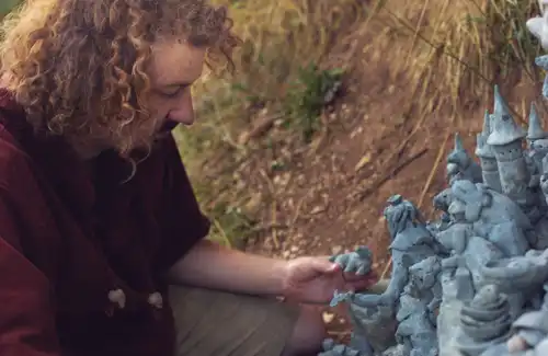 Image du sculpteur suisse François Monthoux devant sa sculpture.